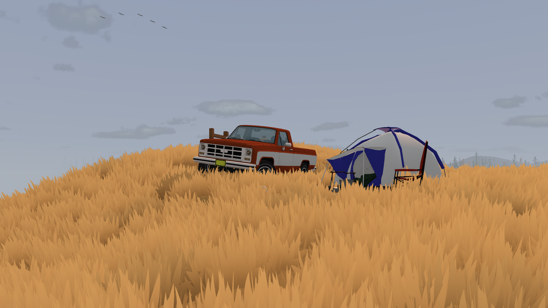 A pickup truck and tent on a grassy hill
